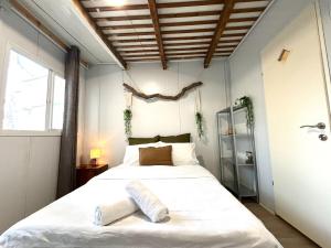 a bedroom with a large white bed and a window at Blue Emerald in Haifa