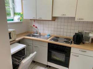 una cucina con mobili bianchi e un forno a piano cottura di Wohnung In Dreveskirchen Mit Kleinem Garten a Blowatz