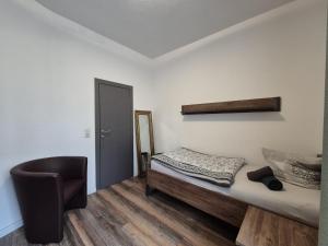 a bedroom with a bed and a chair in it at Mikra Homes24 in Crimmitschau in Crimmitschau