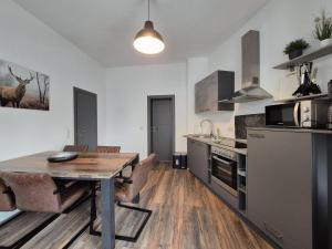 a kitchen with a wooden table and a dining room at Mikra Homes24 in Crimmitschau in Crimmitschau