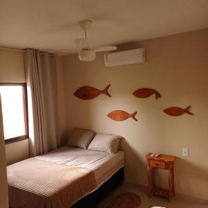 圣阿马鲁Kite House Lençóis II的卧室配有床,墙上挂有鱼标记