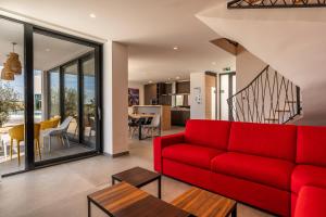 ノヴァリャにあるOlea Residences & Villasの赤いソファとテーブルのあるリビングルーム