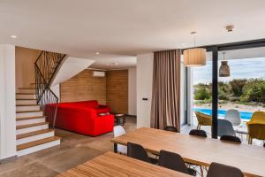 ノヴァリャにあるOlea Residences & Villasの赤いソファとテーブルのあるリビングルーム +6枚の写真