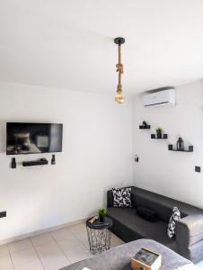 a living room with a couch and a tv on the wall at ESCAPADAS ROMÁNTICAS Gavira Apartamento in Rota