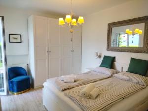 ブレンゾーネにあるVilla Sonjaのベッドルーム(大型ベッド1台、青い椅子付)