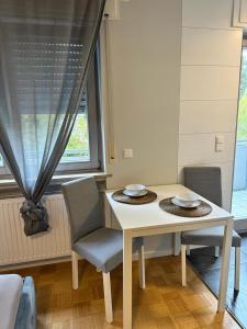 a white table and chairs in a room with a window at Amaroom 4 in Karlsruhe