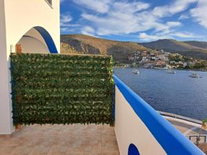 a wall covered in ivy next to a body of water at Kazonis Studios in Kalymnos
