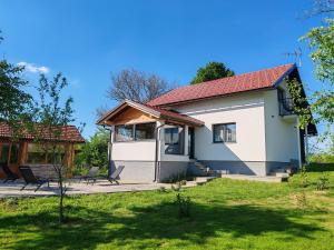 a small white house with a red roof at Holiday home Poljak in Tounj