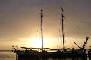 坎彭Historical sailing ship的一艘船停靠在水中，背景是日落 更多4张照片