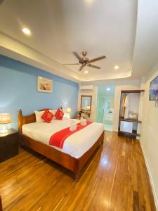 a bedroom with a large bed with a ceiling fan at Golden Lotus Namkhan View in Luang Prabang