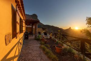 a building with the sunset in the background at Casa Rural Cottage Bentayga in Tejeda