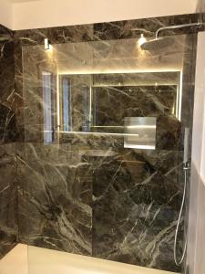 La salle de bains est pourvue d'une douche en marbre noir et d'un miroir. dans l'établissement Chioggia Nice View, à Chioggia 20 autres photos