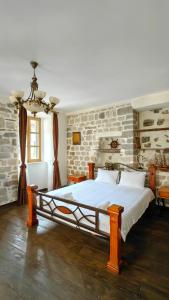 a bedroom with a large bed with a brick wall at Captain Studio in Kotor