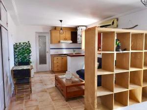 a kitchen with wooden shelves and a table in a room at Estudio en el Castillo de Denia in Denia