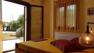 a bedroom with a bed and a large sliding glass door at Villa Politimi at Aegina in Mesargos