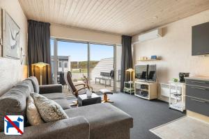 ein Wohnzimmer mit Sofa und Fernseher in der Unterkunft Agger Holidays in Vestervig