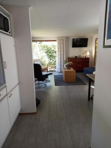 a living room with a couch and a table and a television at Chalet "Uit Zicht" in Putten