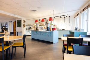a restaurant with tables and chairs and a kitchen at Good Morning Arlanda in Arlanda