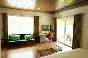una camera da letto con divano, scrivania e tavolo di Nanau Resort & Spa a Ramnagar