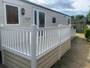 a white fence on the side of a house at Fully adapted caravan in Meliden
