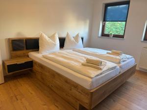 a bedroom with a large bed with white sheets and pillows at K38 Mühlgrabenblick by Selected Rooms in Eisenach