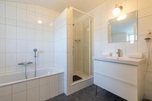 a bathroom with a tub and a sink and a shower at Welcome in - Sint-Anthonijshoek, studio's met eigen tuin, theeschenkerij en pluktuin in Koudekerke +49 photos