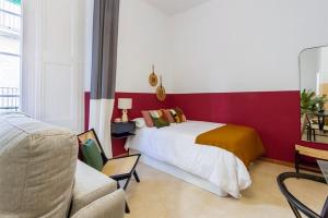 Un dormitorio con una cama y una pared roja. en Hauzify I Loft Tura, en Sant Feliu de Guíxols