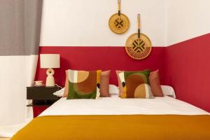 1 dormitorio con 1 cama con pared roja y blanca en Hauzify I Loft Tura, en Sant Feliu de Guíxols