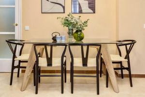una mesa de comedor negra con sillas y un jarrón con flores en Hauzify I Loft Tura, en Sant Feliu de Guíxols