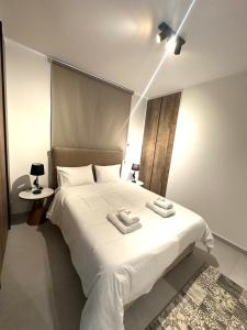 a bedroom with a white bed with two towels on it at Verasia Acute Stay in Engomi in Engomi