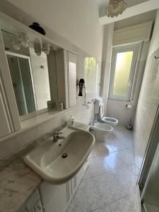 モネーリアにあるCasa Bianca 4 - confortevole in centro a Monegliaの洗面台とトイレを備えた白いバスルーム