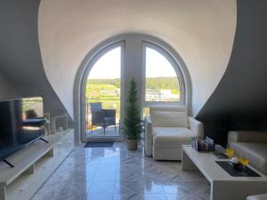 a living room with a large window and a tv at Traumurlaub im Schwarzwald in Dornstetten