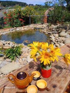 un tavolo con una teiera e fiori gialli sopra di Homestay Đồi Sương Trắng a Kon Rung (1)