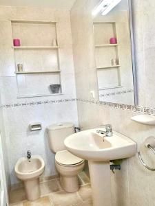 a white bathroom with a toilet and a sink at Estudio en el Castillo de Denia in Denia +23 photos