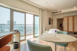 a living room with a table and chairs and a large window at AR Suites KLJ Square in Gurgaon