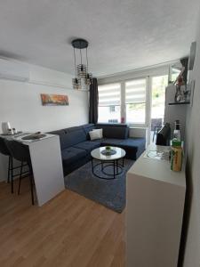a living room with a blue couch and a table at Apartman City in Jajce