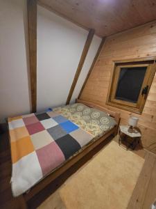1 dormitorio con 1 cama en una habitación con ventana en Durmitor Chill Chalet, en Žabljak