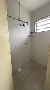 a white bathroom with a shower and a window at Sofea Homestay Tasek Gelugor in Kampong Kubang Menderong