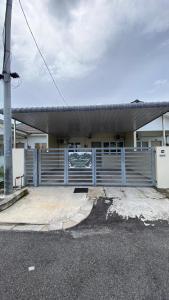 a blue fence in front of a building at Sofea Homestay Tasek Gelugor in Kampong Kubang Menderong