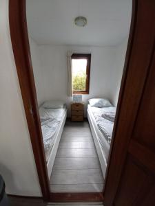 a hallway with two beds in a room with a window at Chalet "Uit Zicht" in Putten