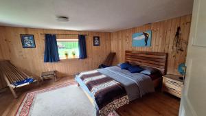 a bedroom with a bed in a room with wooden walls at Divine Lake House in Motnik