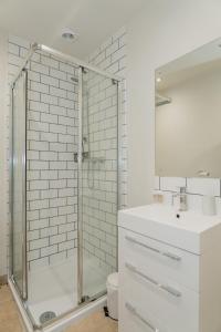 a bathroom with a glass shower and a sink at Duplex Redhill town centre apartment by Livingo Stays in Redhill