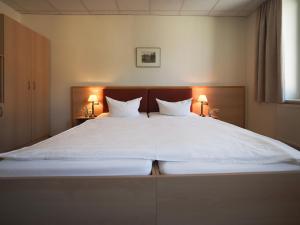 a large bed with white sheets and two pillows at Gasthof Hillig in Bad Gottleuba +22 photos