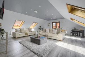 ein Wohnzimmer mit weißen Möbeln und einem Klavier in der Unterkunft Luxury Penthouse Suite - Swansea Central - Beach in Swansea
