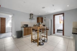 eine Küche mit Tisch und Kühlschrank in der Unterkunft Luxury Penthouse Suite - Swansea Central - Beach in Swansea
