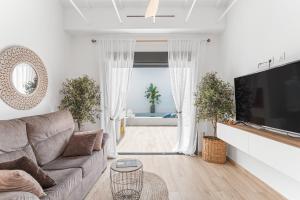 a living room with a couch and a flat screen tv at Casa Catral Alfalfar 12 in Catral