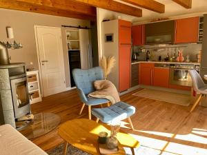 a living room with a blue chair and a table at Ferienhaus Biedermann in Wiek auf Rügen