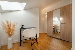 a room with a table and a chair and a mirror at Le Petit Saint Martin - Duplex - Cœur de ville in Soissons