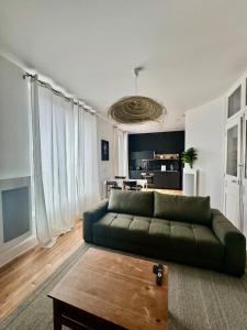 a living room with a green couch and a table at Pura vida in Soissons