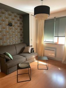 a living room with a couch and two tables at Charmant Studio au coeur de Castanet-Tolosan in Castanet-Tolosan +1 photo